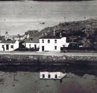 Circa 1960’s. Loch Carron Handloom Weavers with ruin of Urquhart’s House behind Fuchsia Cottage and Coille Bhurich.